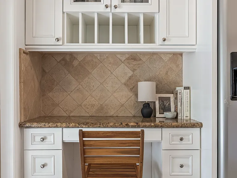 Fully stocked kitchen with abundant natural light, backyard views, bar seating, and a convenient work station for everyday living.