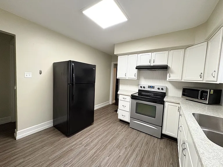 Large kitchen space with newer appliances and cabinets.