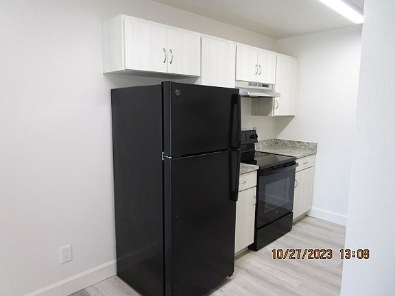Kitchen with new Black Refrigerator and Black full size glass top stove/oven