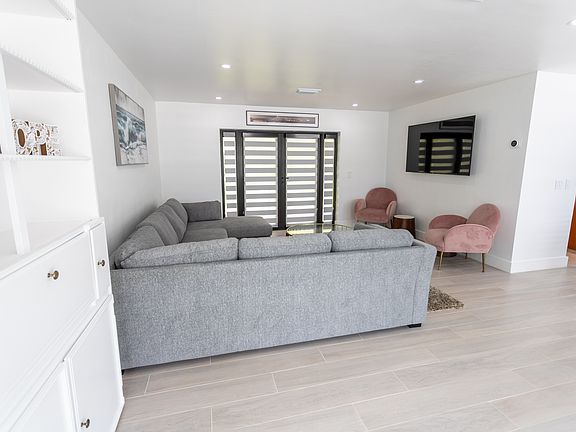 view of living room with patio doors in the background that lead to enclosed patio