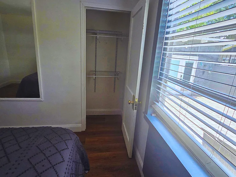 Spacious closet, stylish nightstands, bedside lamp, and elegant window blinds.