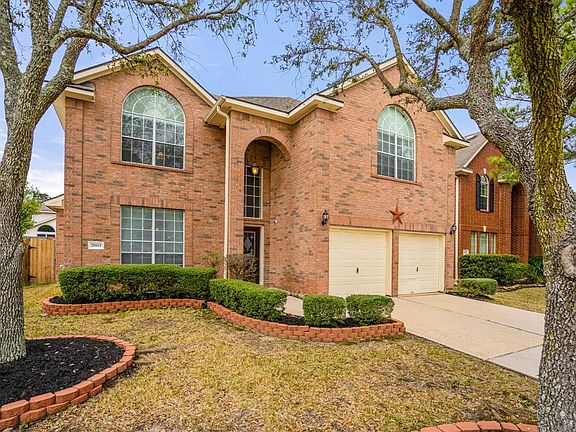 LET'S TAKE A MOMENT TO APPRECIATE THIS CURB APPEAL! Colors pop with the expertly placed landscaping bricks and the beautiful greenery! The garage features built ins and ceiling brackets for extra storage!
