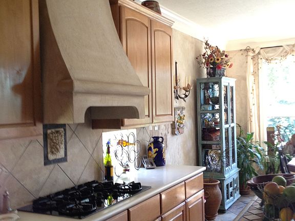 Plaster vent hood, custom backsplash & island are featured in the Kitchen.