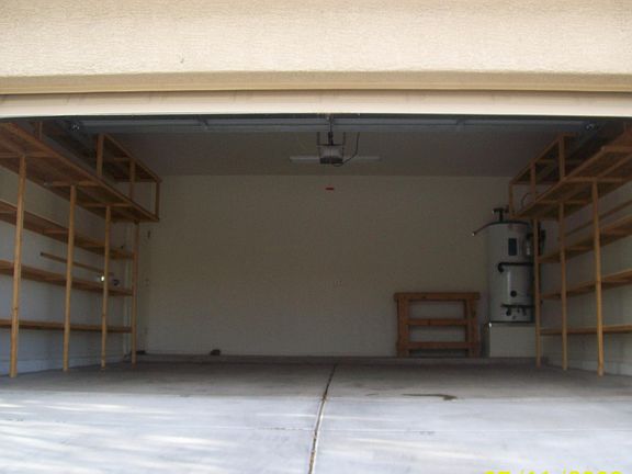 2 car garage with plenty of homemade wood shelving.