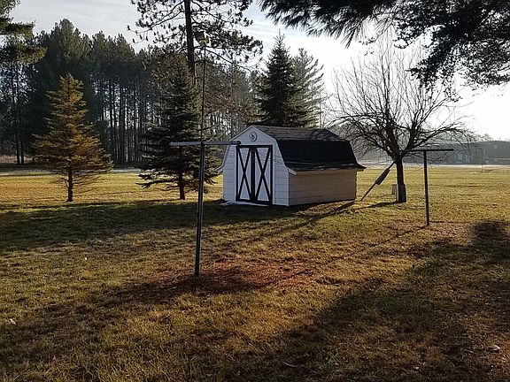 Clothes line, shed, and apple tree behind house.