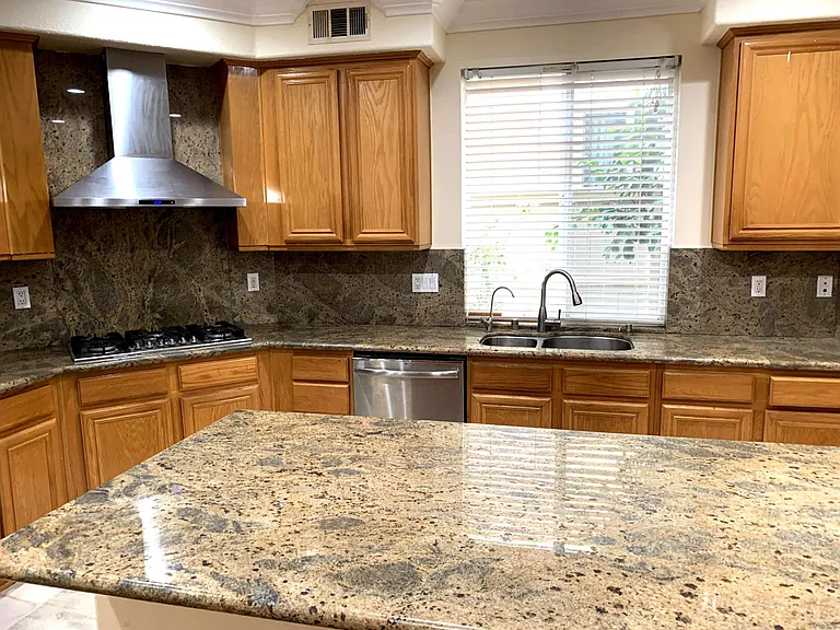 Kitchen with stainless steel - sink, fridge, stove and hood