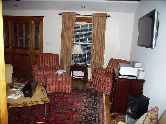 Formal living/dining has split brick and hardwood floors and leaded glass door