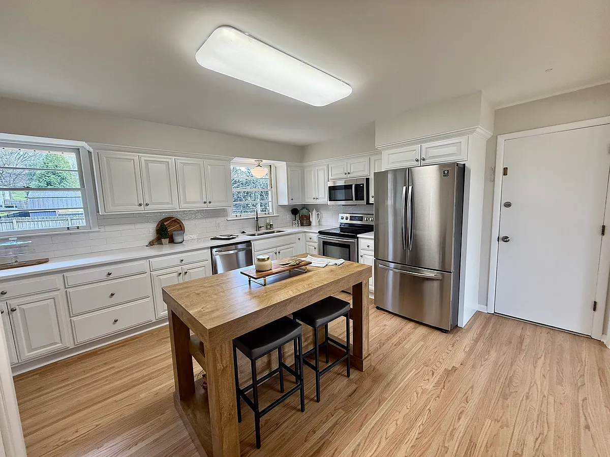 Another view of the large kitchen. new light fixture over the sink, tiled backsplash, lovely quartz countertops and new hardwood floors... - 7161 Willow Creek Dr