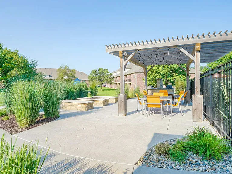 Take in the fresh air from the pergola-covered seating and grill area, perfect for sunny days.