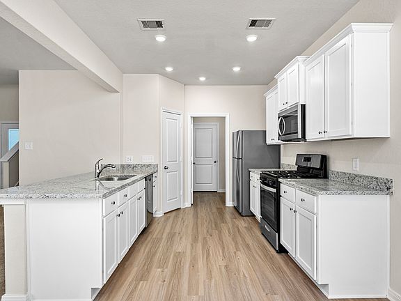 The chef-ready kitchen features granite countertops and stainless-steel appliances.