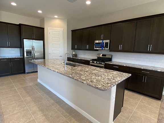 Large kitchen with pendants lights being installed