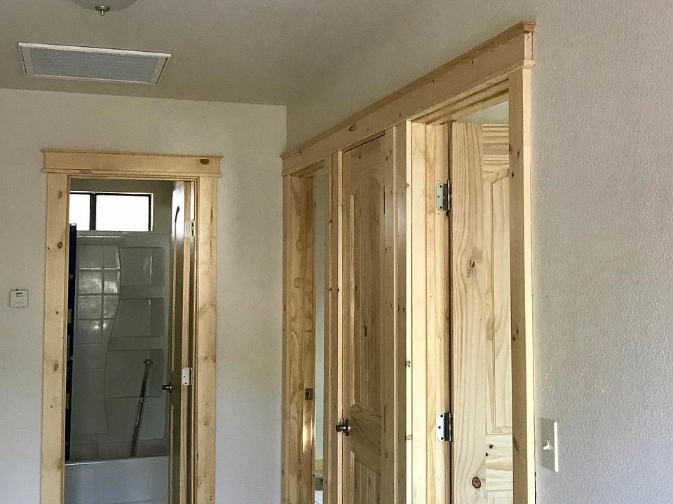 Hall and doors to bedrooms and bathroom. Custom solid pine doors and trim. Custom tile floors.