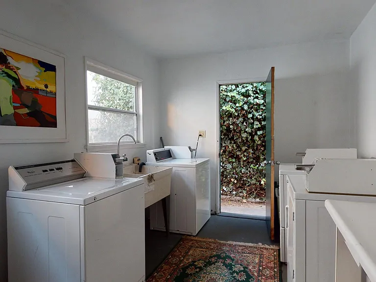 Huge Laundry room with LARGE folding table & Double sinks. Cabinets. Loads of Natural Light & A Sunny Courtyard dedicated to hang drying clothes on clotheslines !