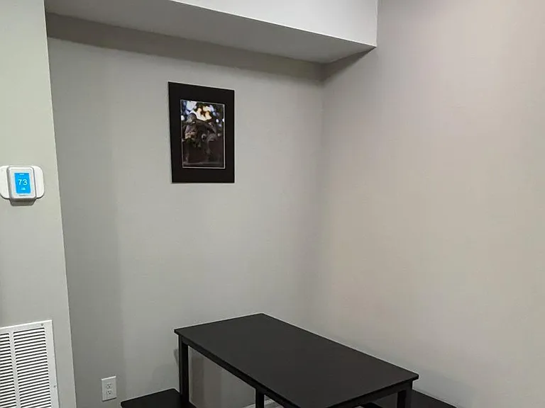 Dedicated dining nook with a table and bench seating, finished with durable flooring and overhead lighting for daily meals.