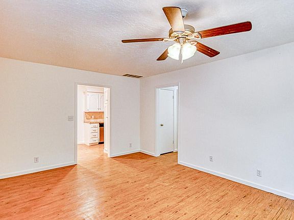 Living room with view of kitchen and hallway to bedrooms shown