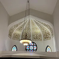 Church common space with original chandelier and stain glass windows