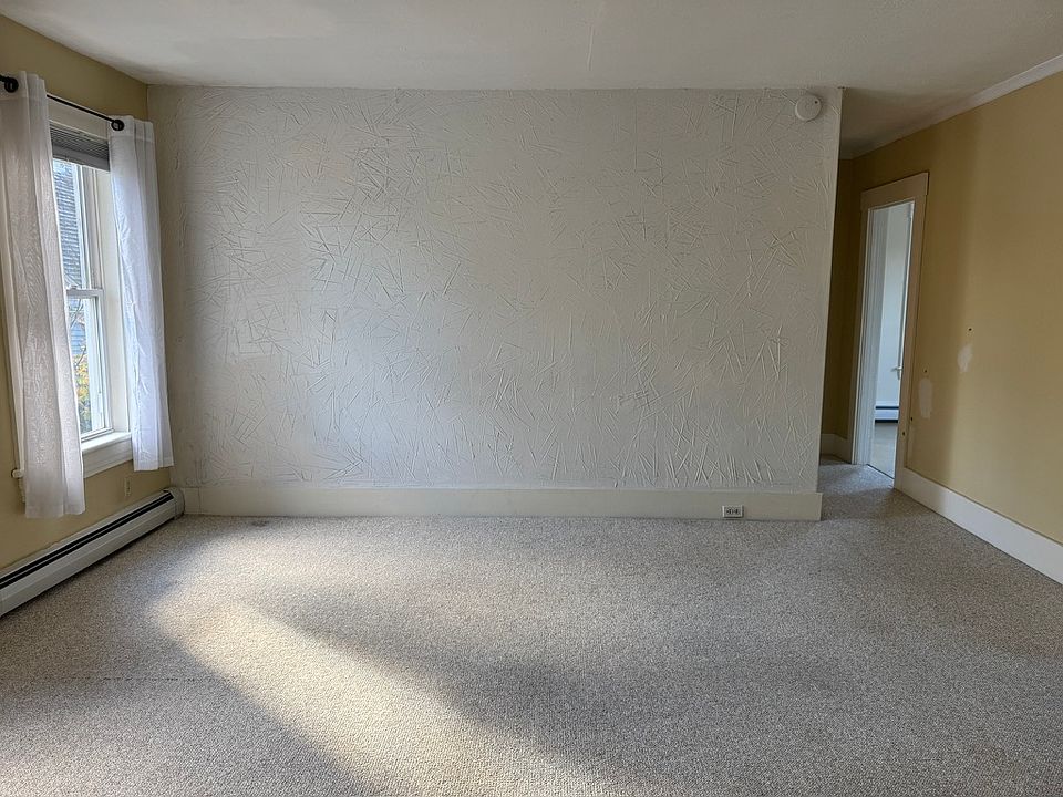 Living room with hallway to home office/bedroom on left and kitchen on right.