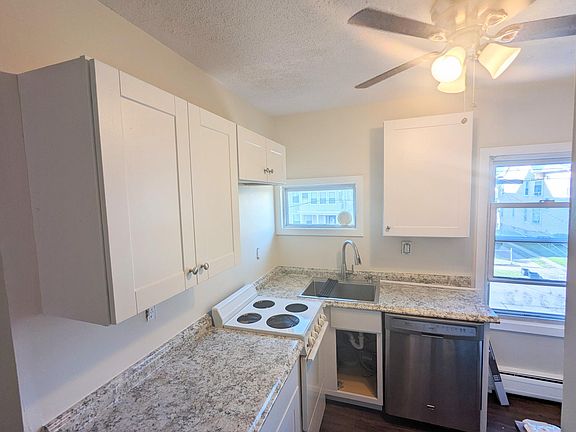 Another view of kitchen showing ceiling fan & windows