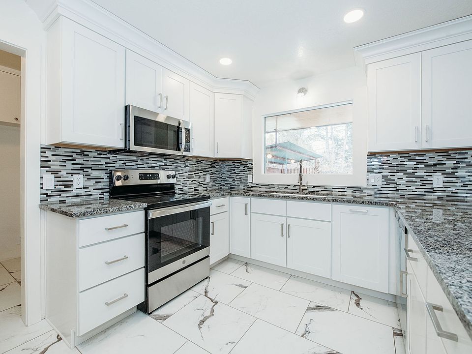 Kitchen with granite counters, new appliances, and glass backsplash