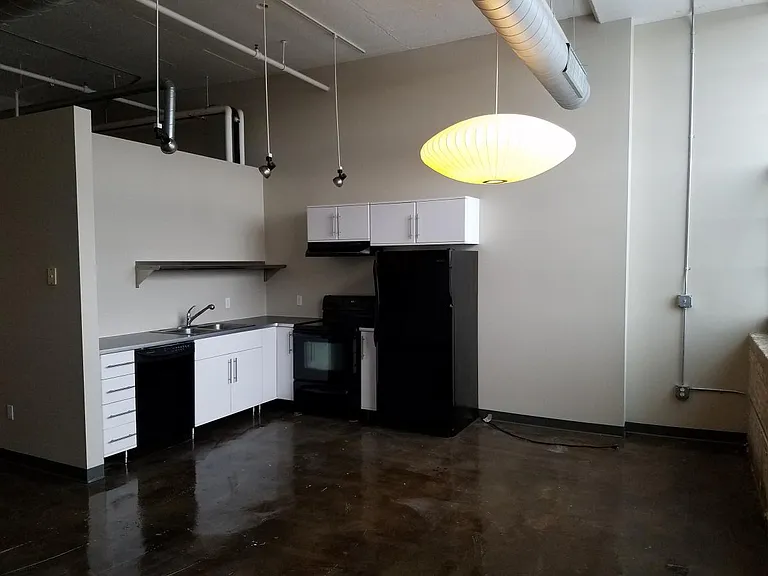 Furnished kitchen with large double sink. Additional shelving has been installed above sink.
