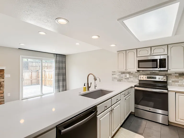 Newly remodeled kitchen includes new dishwasher, refrigerator, oven and microwave