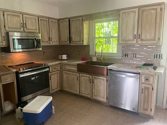 The kitchen has updated stainless steel appliances, sink and garbage disposal. Antique style cabinets butcher block counter tops and tile floors. It features beautiful farm house lighting in the kitchen and dining.