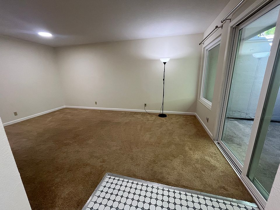 Spacious living room with large glass sliding door leading to a relaxing balcony.
