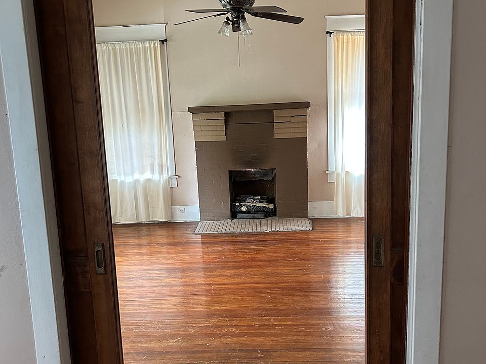 View from side room to entrance room showing fireplace and pocket doors that allows for partition when closed.