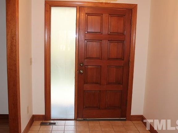 Real wood front door and tiled floor in foyer.