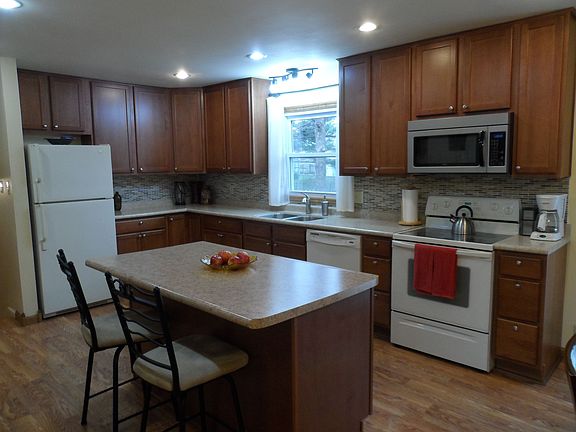 Eat-in Kitchen features stunning glass tile backsplash, pantry and island.