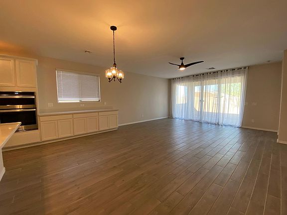 Dining in Great Room. Wall-of-Glass patio doors. Upgraded lighting & tile plank flooring