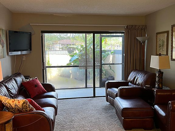 Lanai off of living room includes chairs and side table not shown.