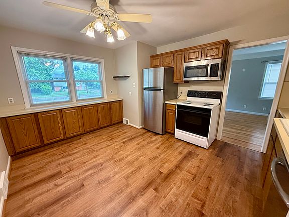Spacious dining room and kitchen with fridge, microwave, oven, and dishwasher