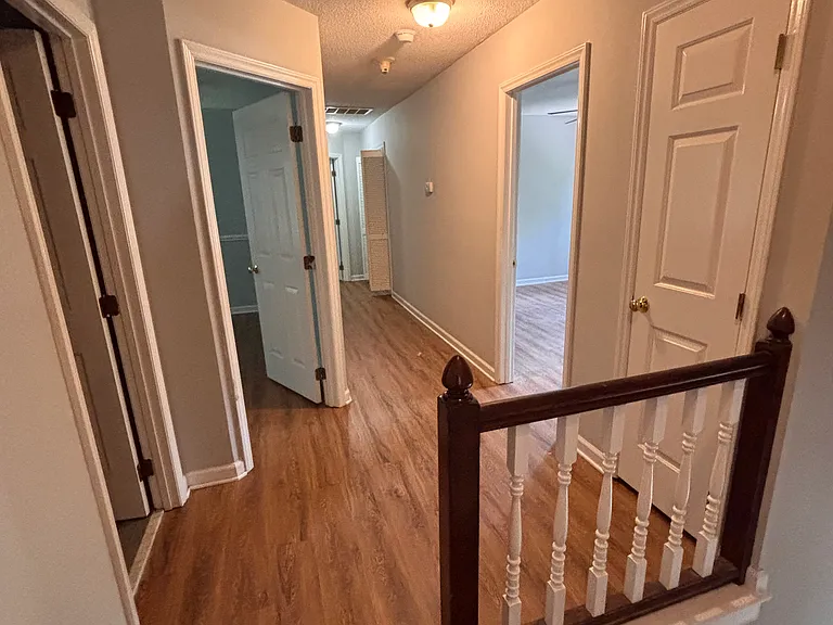 hallway with 3 bedrooms showing.
