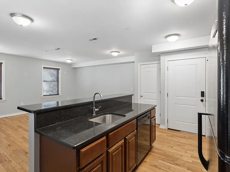 Open kitchen with a large breakfast bar, sink, and generous counter space, flowing into the main living area.