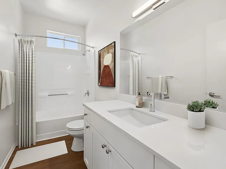 Renovated Package I bath with white quartz countertop, white cabinetry, and hard surface flooring