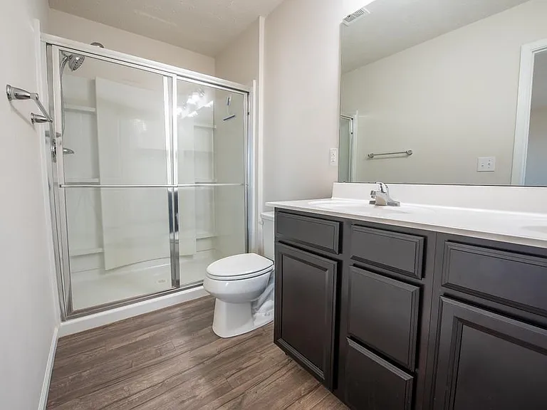 Adjoining Primary Bathroom Features a Double Vanity and Shower.