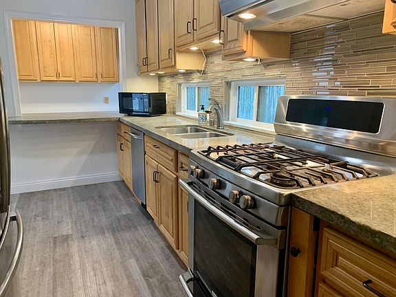 Dishwasher and stainless refrigerator. Breakfast bar area looks towards office nook.