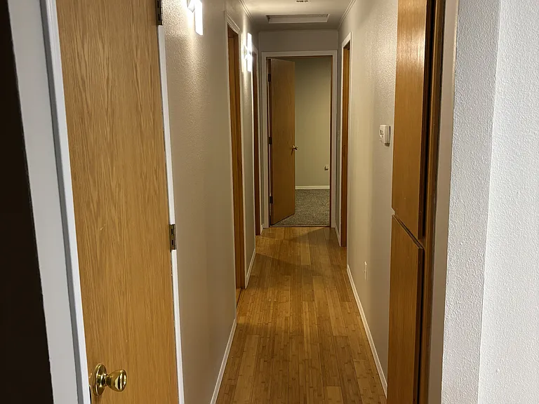 Hallway view going from the living room to the main floor bathroom and 3 bedrooms