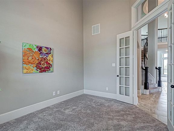 Study with French doors is at the entrance with stylish transom window located above.