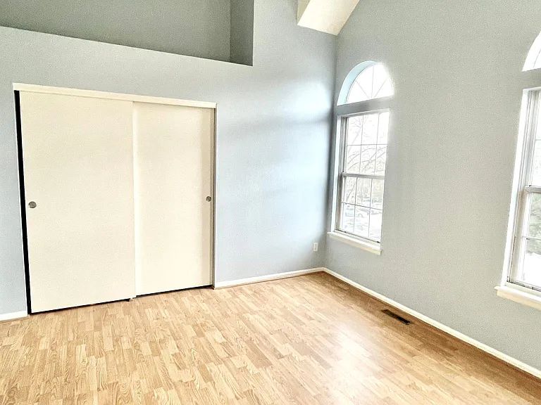Second upstairs bedroom with large windows and vaulted ceilings