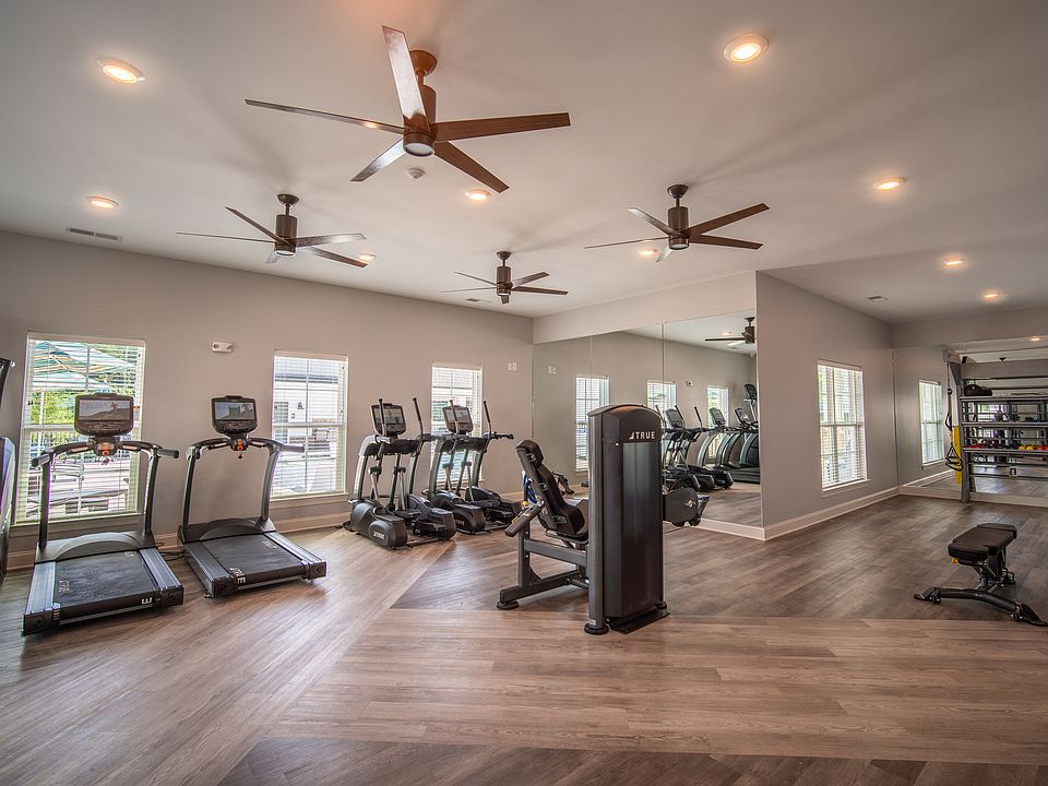 Modern fitness center with state-of-the-art cardio machines, free weights, and a mirrored wall for a spacious feel.