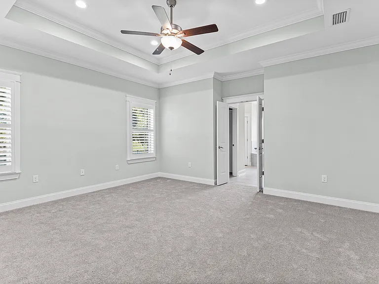 Primary bedroom with tray ceiling en suite