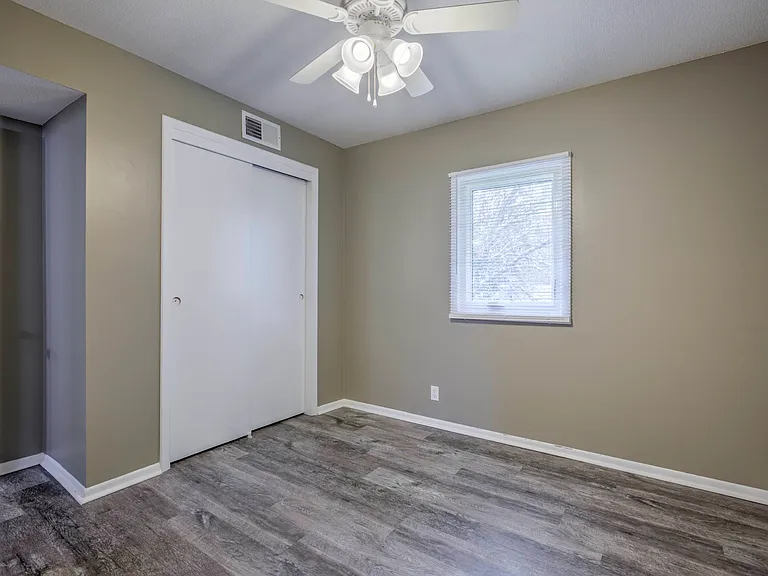 Large closet with a white door in a bedroom at Ashland Park Apartments.
