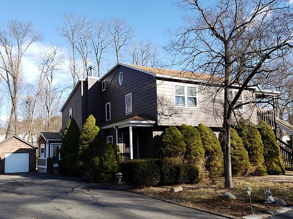 Angled view of rental home from driveway, and detached one-car garage
