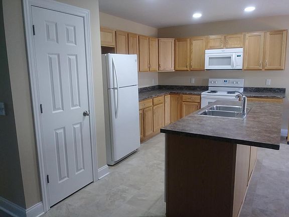 Kitchen equipped with range, refrigerator, dishwasher and microwave.