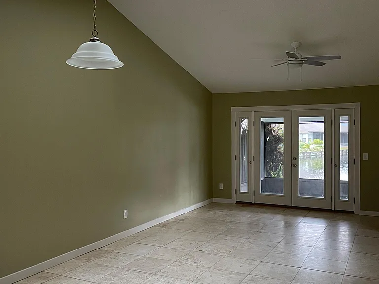 Family room, Vaulted ceilings with skylights letting in natural light. Notice water view even from inside the home. Travertine tile throughout all main areas.