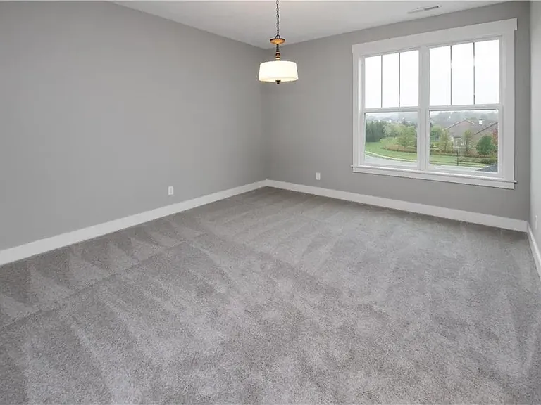 Primary bedroom is very good sized; easily accommodates king sized bed; barn door leads to bath and walk in closet