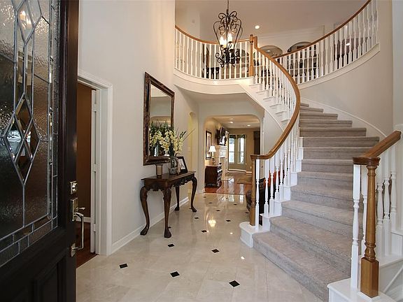 Tasteful Elegance Abounds from the Marble with Granite Inset Flooring to the Sweeping Staircase and Stunning Chandelier.