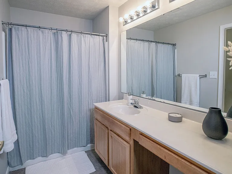 Primary bathrooms offer a lavish vanity area with dual lighting and a delightfully oversized mirror, preparing you for the day.
